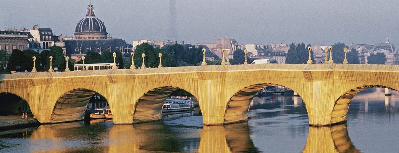 The Pont Neuf Wrapped, Paris, 1975-85. Le plus ancien pont existant de Paris apparaît ici couvert de polyamide couleur « pierre calcaire dorée », fin septembre 1985, devant le dôme de l’Institut de France et la tour Eiffel.