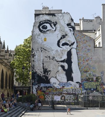 Jef Aérosol place Igor-Stravinsky. Ses œuvres reflètent, en noir et gris, les portraits de figures célèbres ou d’anonymes. À côté du Centre Pompidou, cet autoportrait apparaît comme une invitation à laisser place au silence.