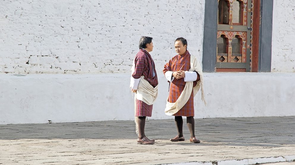 Bhoutanais portant le costume traditionnel, le gho, qui ressemble à une longue robe arrivant aux genoux.