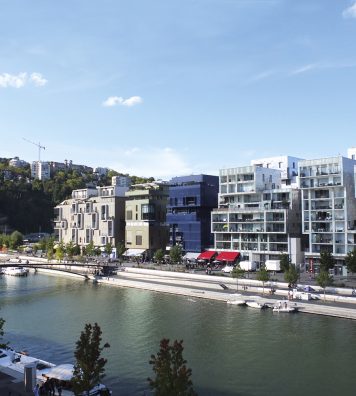 La darse, le bassin rectangulaire au cœur de Confluence. Un espace public majeur du quartier, desservi par une navette. En bas : un immeuble de logements mixtes (libres et sociaux), commerces en rez, de Massimiliano Fuksas (2010).