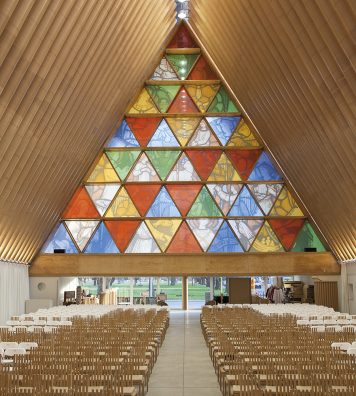 Cardboard Cathedral à Christchurch, en Nouvelle-Zélande. Sous la nef de la cathédrale, les verres triangulaires font écho à la forme du bâtiment. Le mobilier a aussi été dessiné par Shigeru Ban.