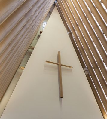 Cardboard Cathedral à Christchurch en Nouvelle-Zélande. Au-dessus de la croix, la structure en tubes de papier du toit est complètement visible, ce qui met un accent sur le caractère éphémère du bâtiment, mais qui ne nuit nullement à sa solennité.