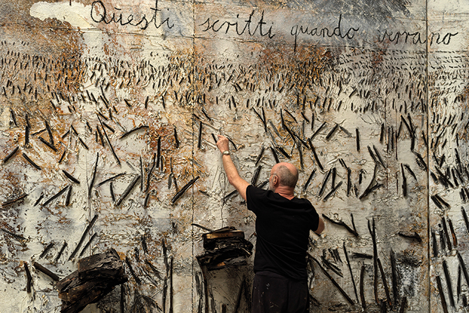 Anselm Kiefer en train de peindre une des toiles exposées au Palazzo Ducale de Venise.