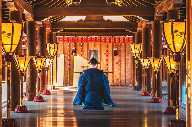 Un prêtre shinto en prière dans un temple.